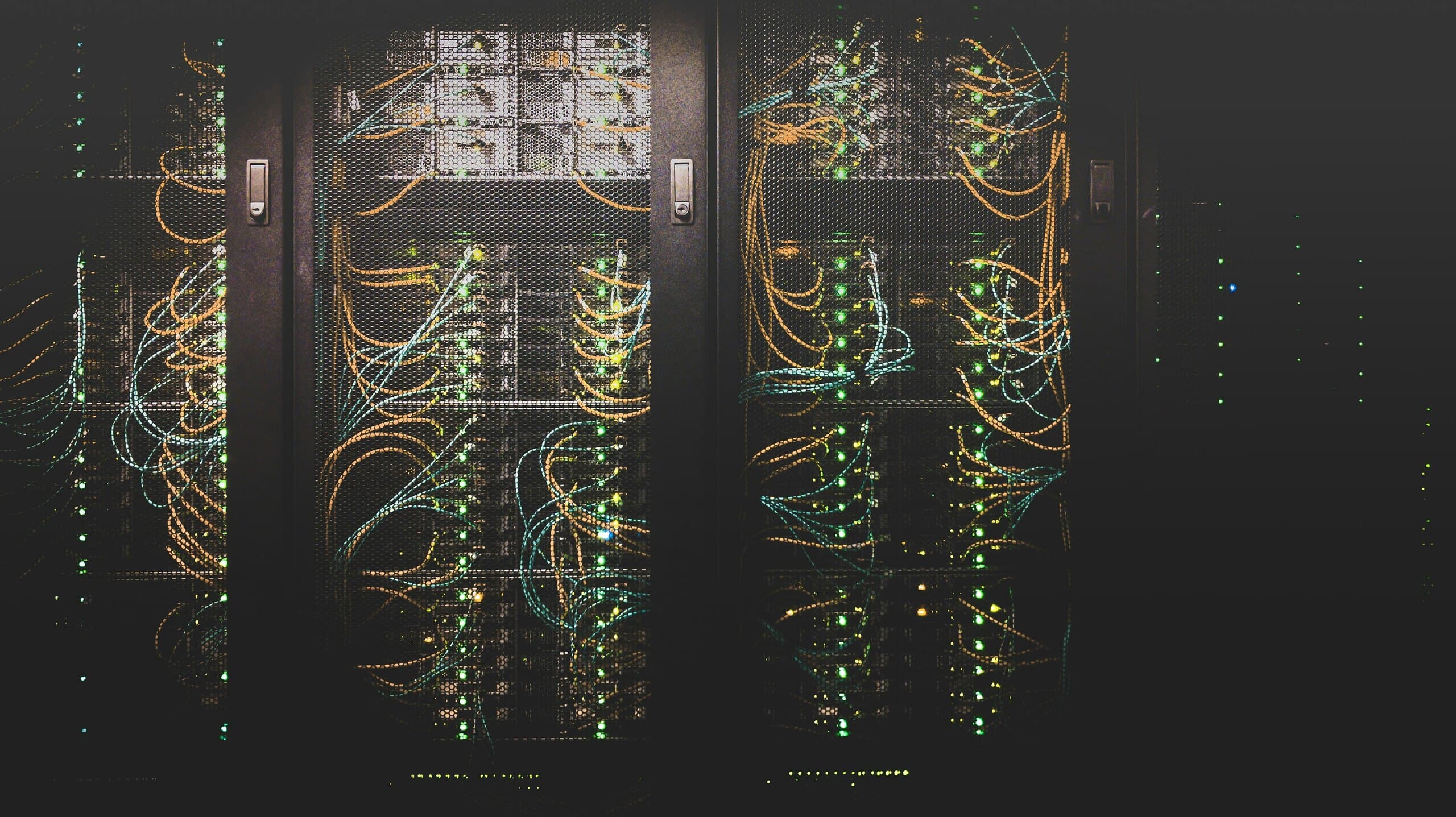 Server cabinets with fiber and copper cabling behind mesh doors