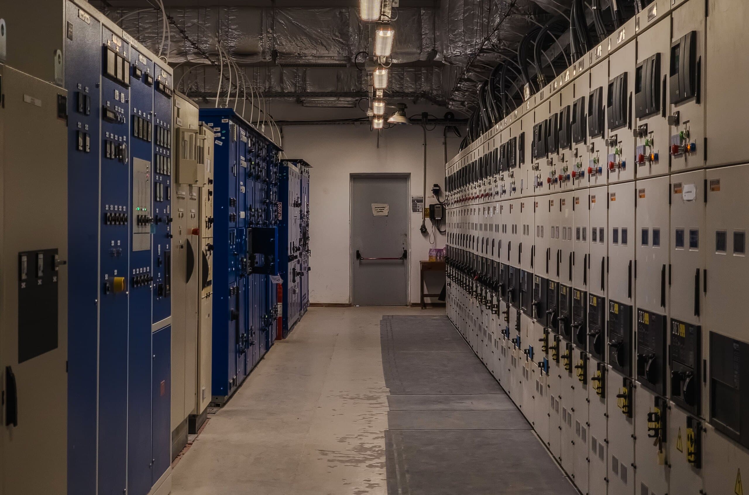 A switchgear room with medium voltage panels on both sides of the aisle
